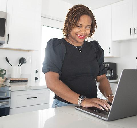 一个女人在厨房里用笔记本电脑工作